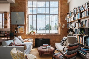 Loft living room with bookshelves and a bay window